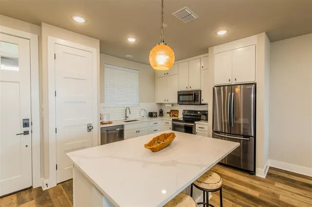 a kitchen with a table chairs refrigerator and microwave