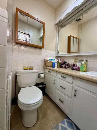 a bathroom with a toilet a sink and mirror