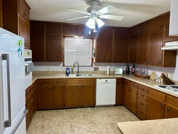 a kitchen with stainless steel appliances granite countertop a sink refrigerator and cabinets