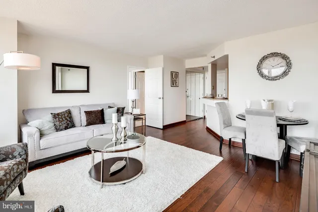 a living room with furniture a clock and a table