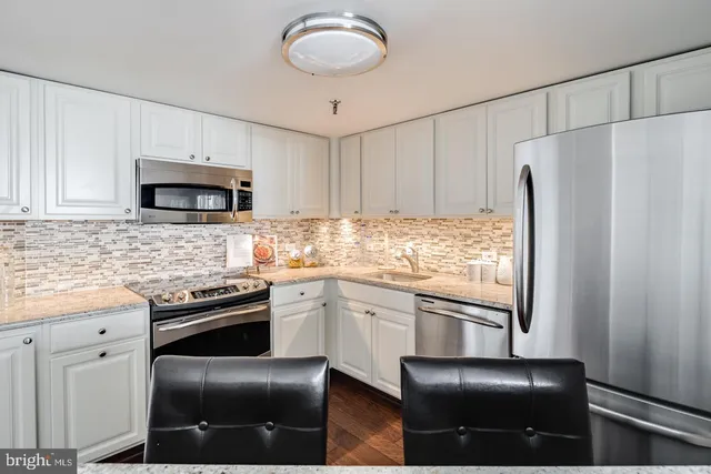 a kitchen with granite countertop cabinets and steel stainless steel appliances