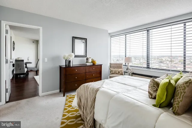 a bedroom with a bed and a dresser next to a window