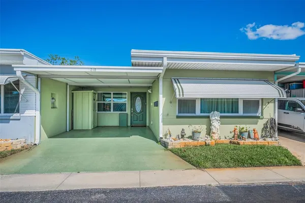 a front view of a house with a garden and yard