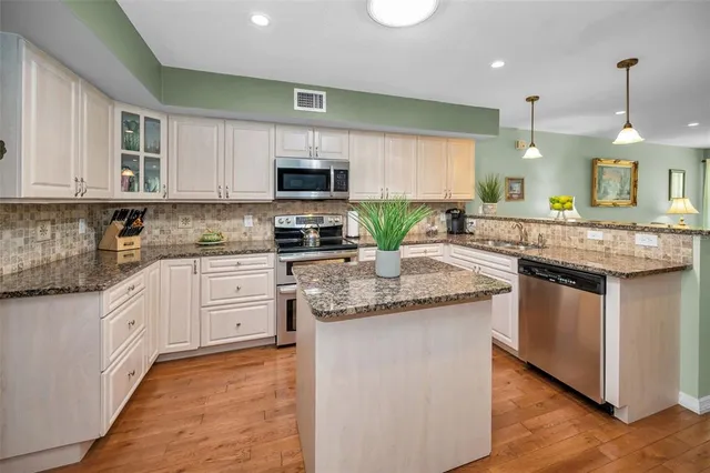 a kitchen with granite countertop kitchen island cabinets and appliances