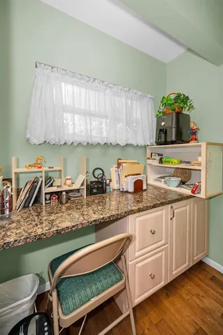 a kitchen with granite countertop a sink a stove and cabinets