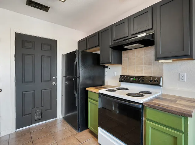 a kitchen with stainless steel appliances granite countertop a stove a refrigerator and a sink