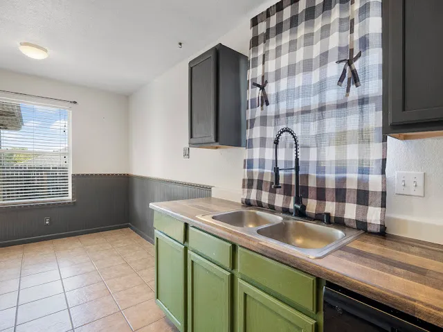 a kitchen with a sink a stove and cabinets