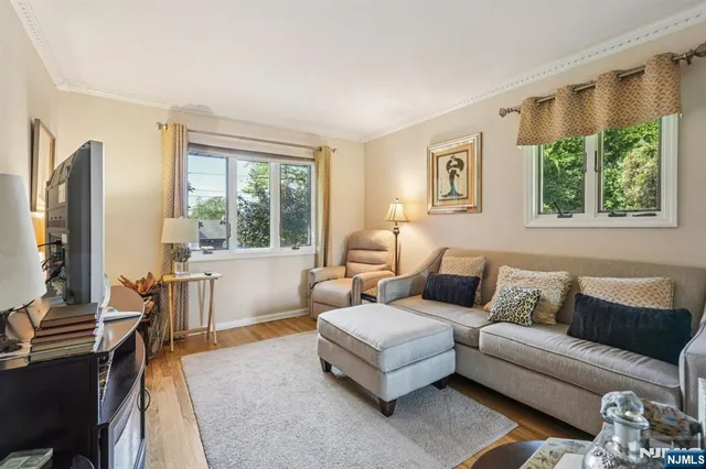 a living room with furniture a large window and a flat screen tv