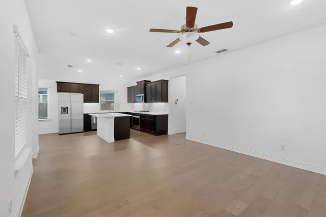 a kitchen with stainless steel appliances granite countertop a refrigerator a sink a stove and oven