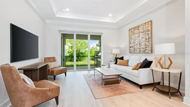 a living room with furniture a flat screen tv and a floor to ceiling window