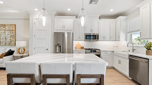 a kitchen with stainless steel appliances a sink stove a refrigerator and cabinets