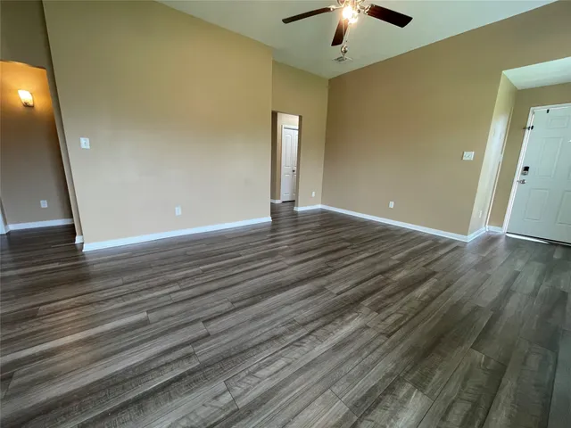 a view of a livingroom with wooden floor and a ceiling fan