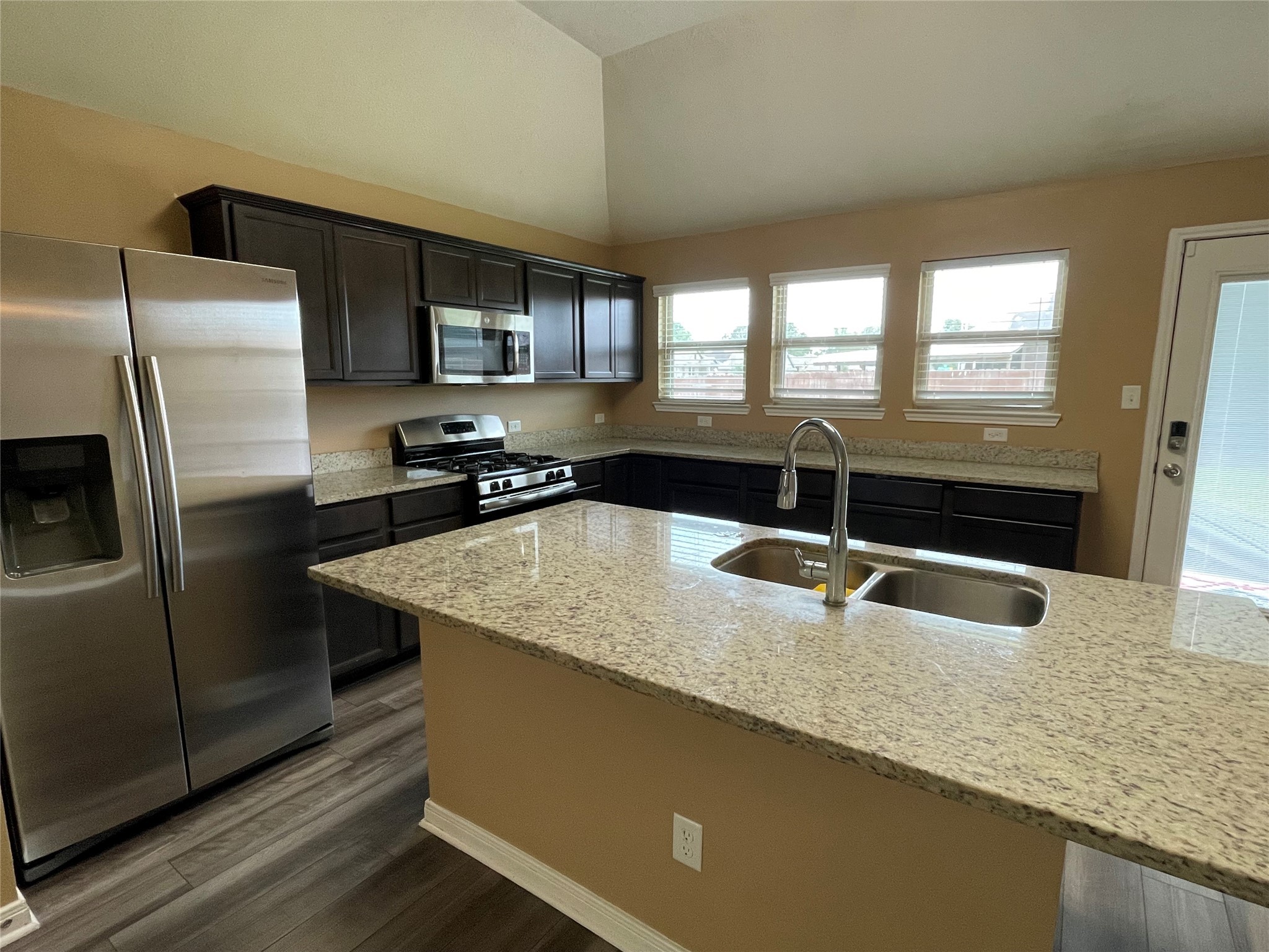 832 Mockingbird Street Navasota, TX 77868 - Photo 5 of 20 a kitchen with granite countertop a sink a counter top space and stainless steel appliances