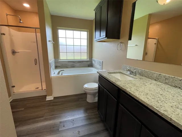 a bathroom with a granite countertop toilet sink and mirror