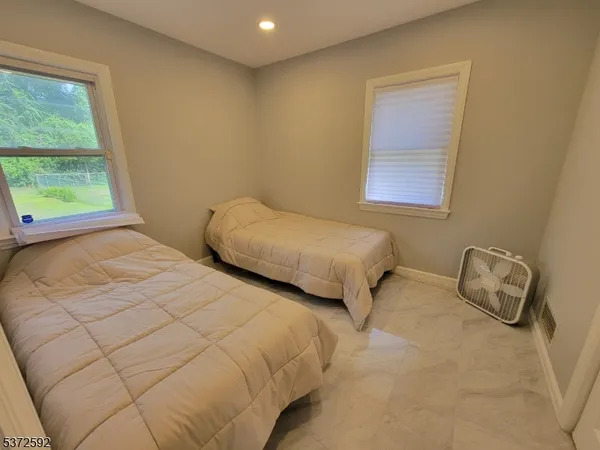 a bedroom with two beds and a window