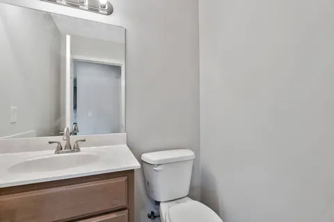 a bathroom with a sink a toilet and a mirror