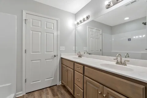a bathroom with double vanity sinks and a mirror