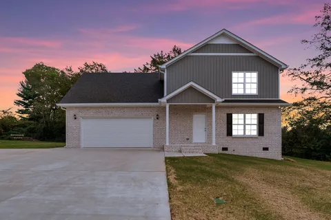 a front view of a house with a yard and garage