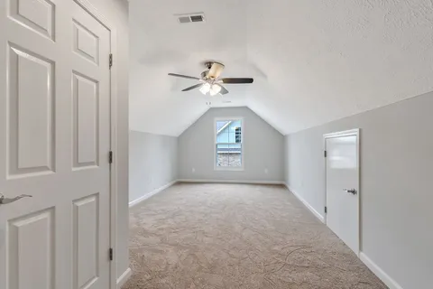 an empty room with fan and windows