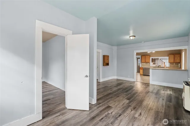 a view of a hallway with wooden floor and a living room