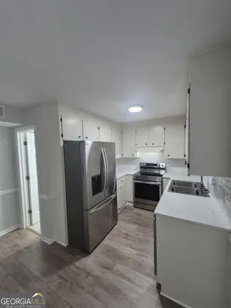a kitchen with refrigerator a microwave and sink