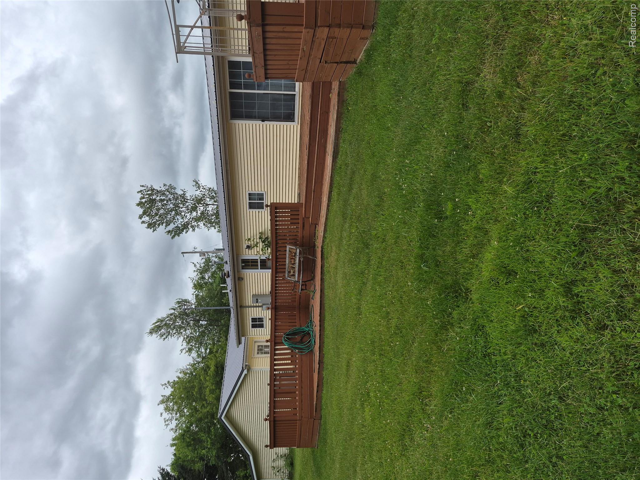 12849 South Delaney Road Perry, MI 48872 - Photo 7 of 34 Expansive lawn with a multi-level wood deck and integrated wood railings