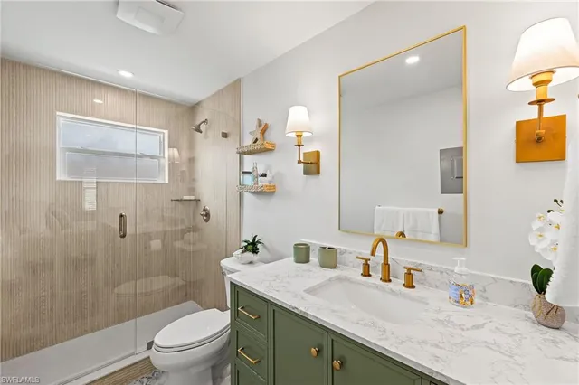 a bathroom with a granite countertop sink mirror toilet and shower