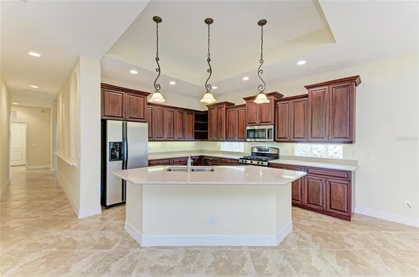a kitchen with stainless steel appliances granite countertop a sink a stove and a refrigerator