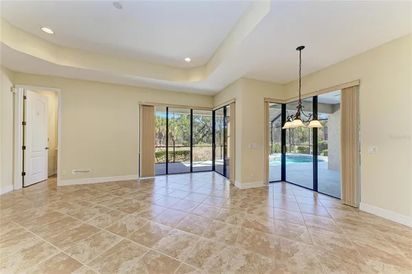 an empty room with a ceiling fan and glass door