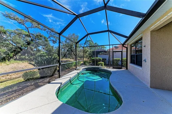 a patio with a table and chairs under an umbrella with a fire pit