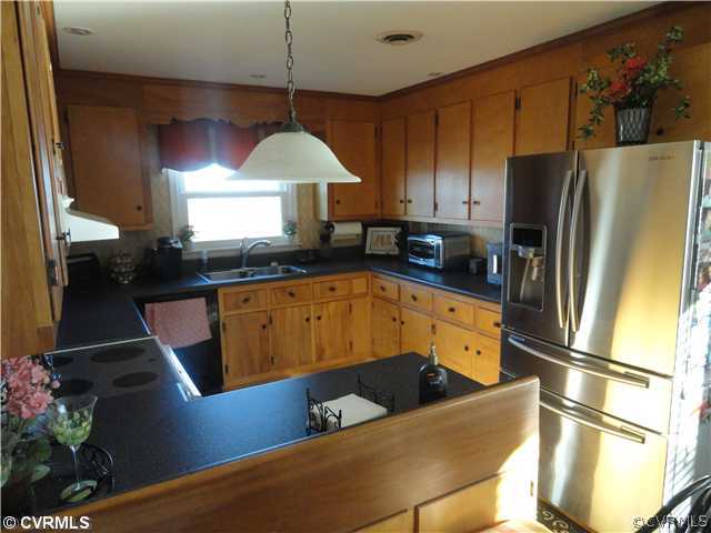 19503 Courthouse Road Dinwiddie, VA 23841 - Photo 7 of 21 a kitchen with stainless steel appliances granite countertop a sink a refrigerator and a stove