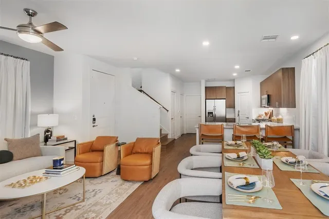 a living room with furniture kitchen view and a chandelier