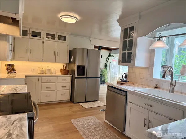 a kitchen with appliances a sink and cabinets