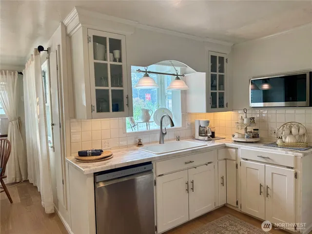 a kitchen with cabinets appliances a sink and a window