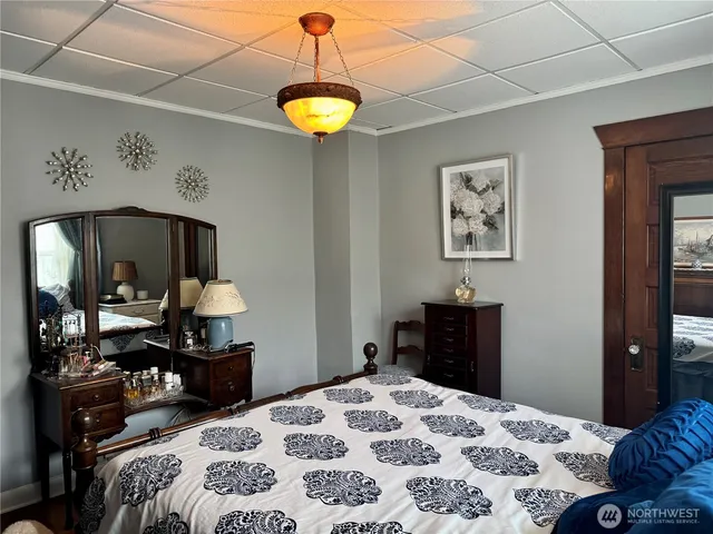 a bedroom with a bed and a lamp on dresser
