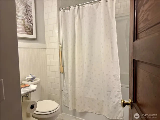 a bathroom with a toilet and shower curtain