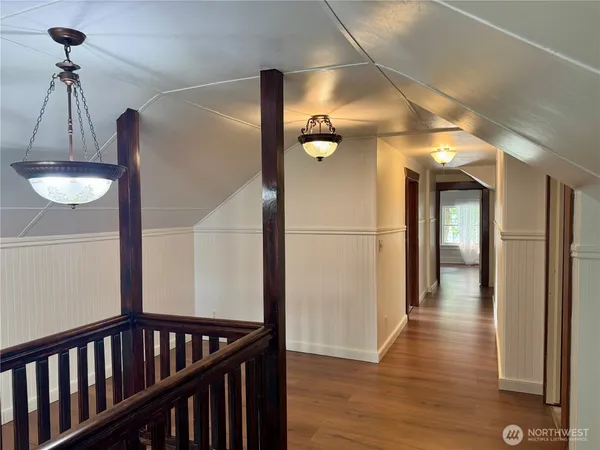 a view of a hallway with wooden floor and staircase
