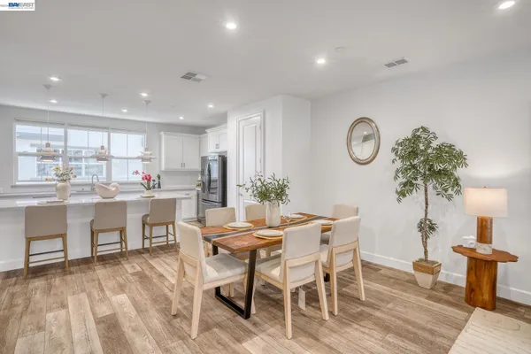 a kitchen with stainless steel appliances granite countertop a sink a stove a dining table and chairs