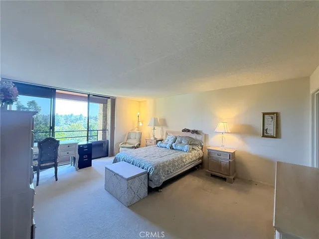 a spacious bedroom with a bed and large windows