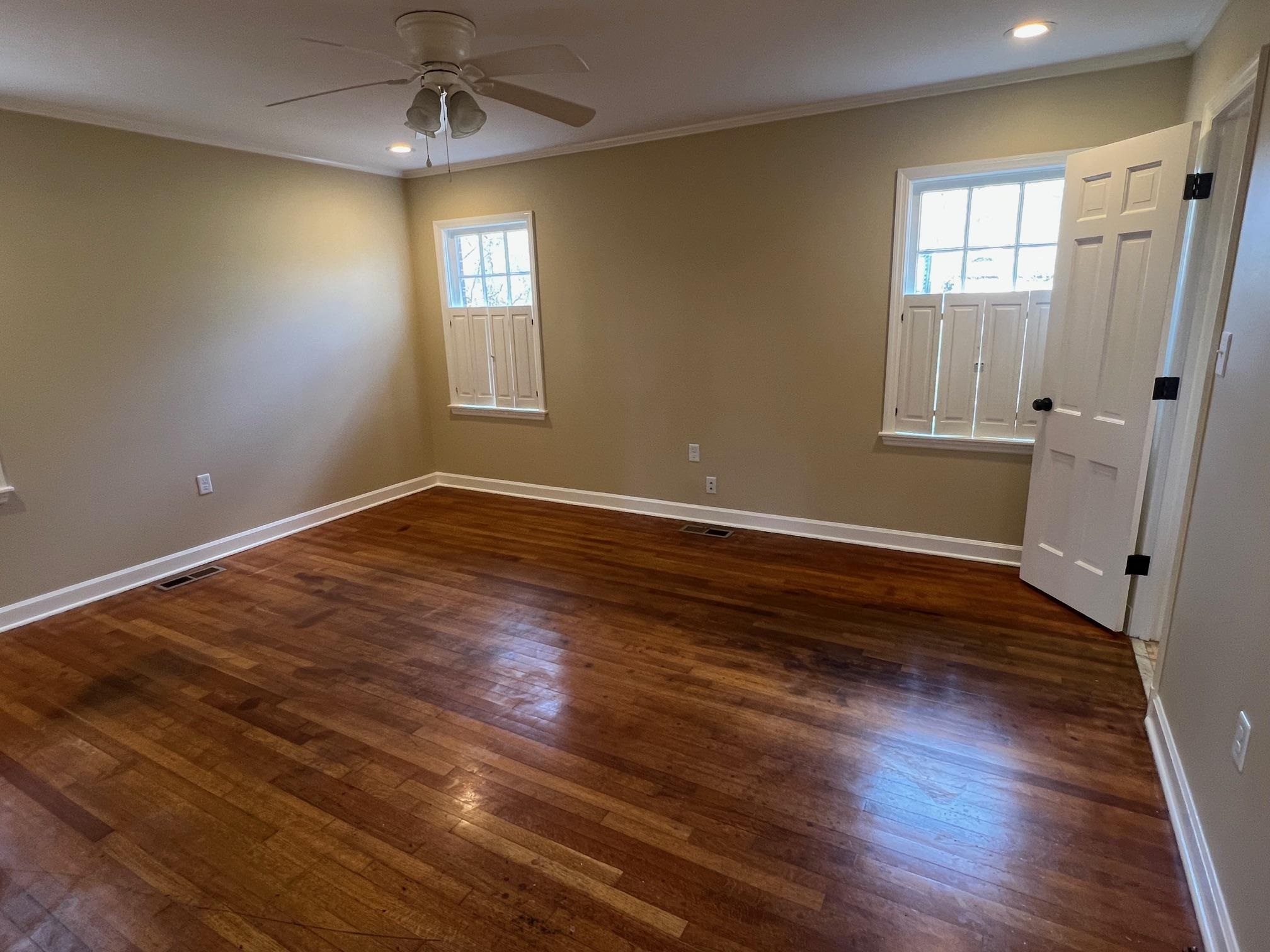 262 East Poplar Avenue Collierville, TN 38017 - Photo 12 of 19 an empty room with wooden floor and windows