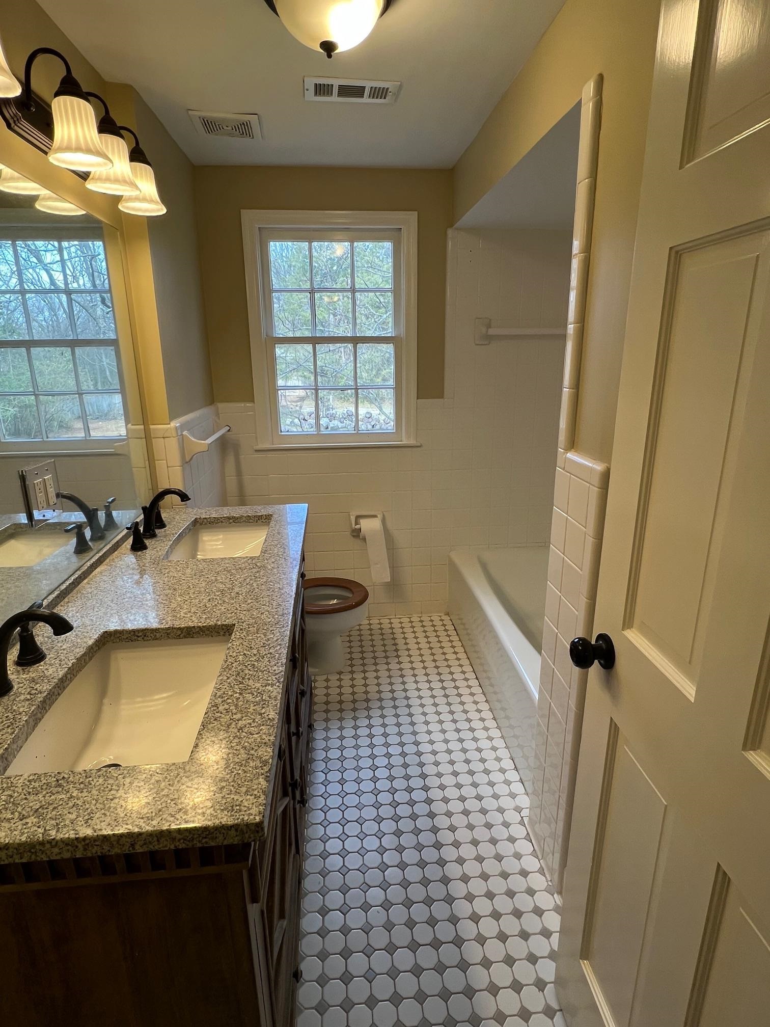 262 East Poplar Avenue Collierville, TN 38017 - Photo 13 of 19 a bathroom with a granite countertop sink a toilet a mirror and window