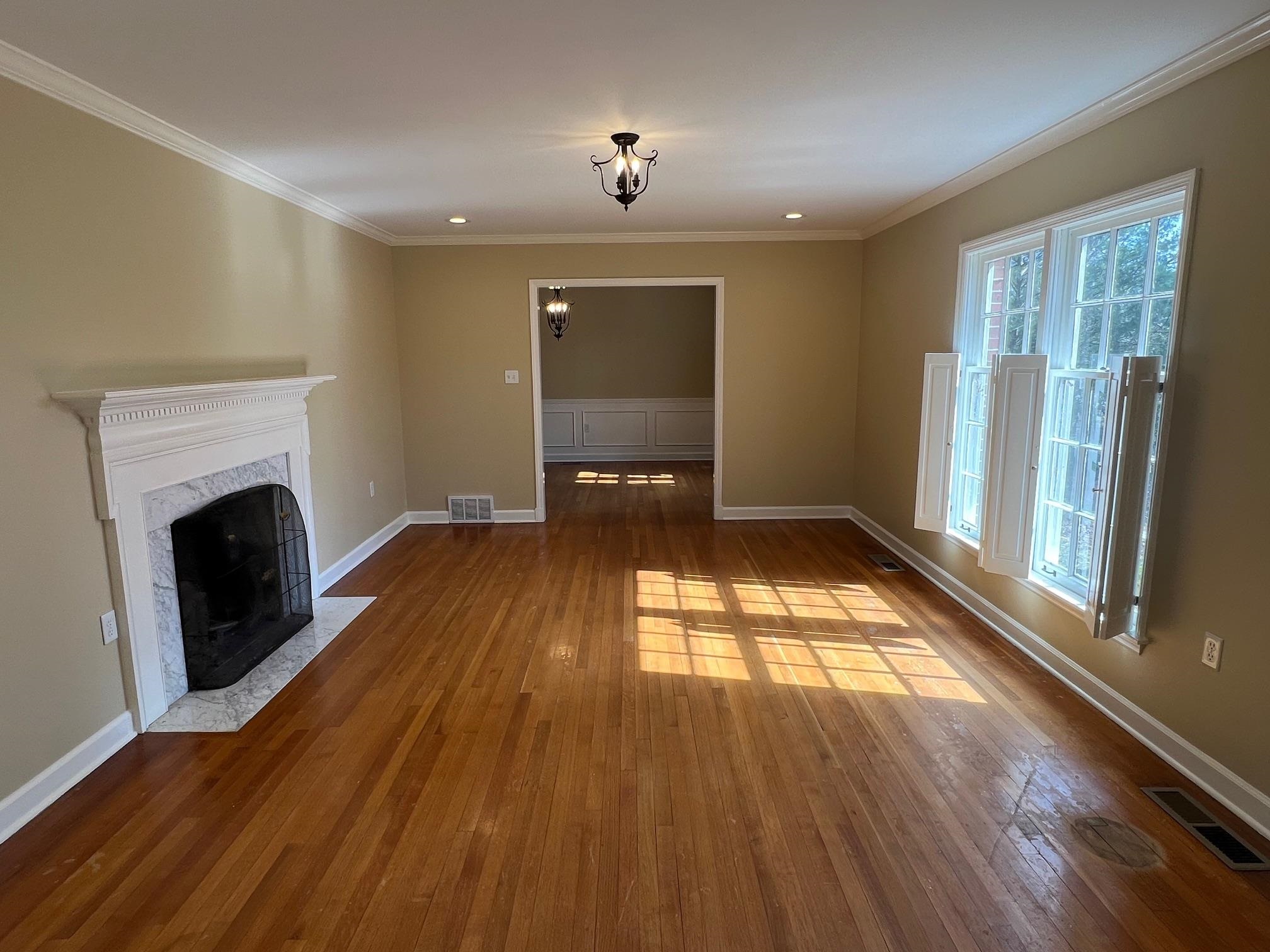 262 East Poplar Avenue Collierville, TN 38017 - Photo 2 of 19 a view of empty room with wooden floor and fireplace