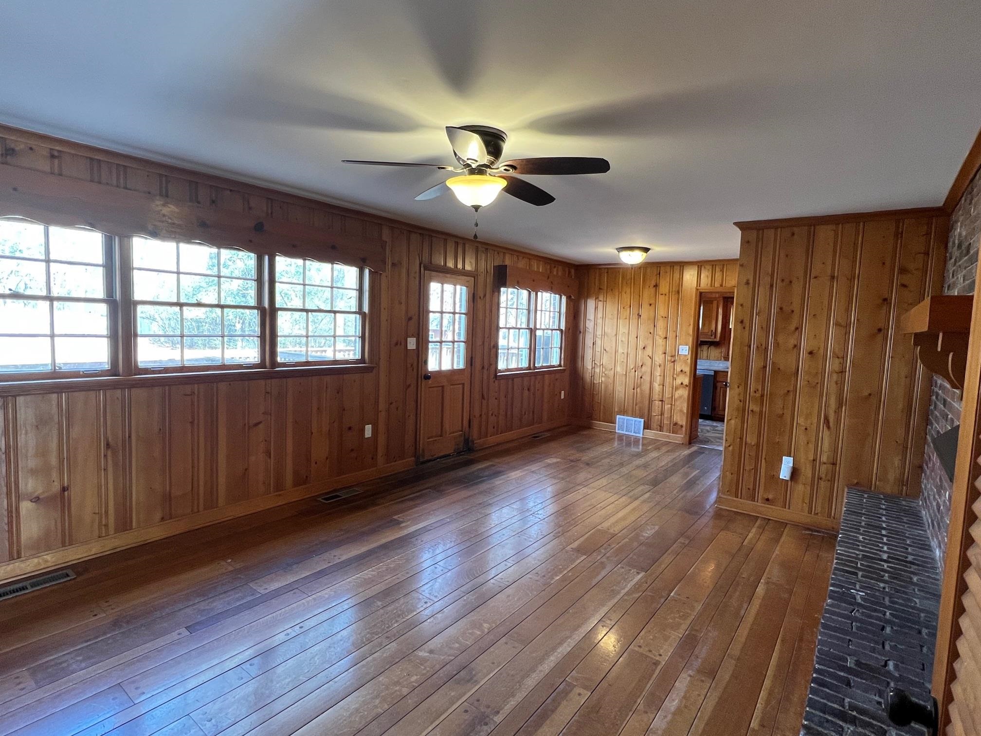 262 East Poplar Avenue Collierville, TN 38017 - Photo 5 of 19 a view of an empty room with wooden floor and a window