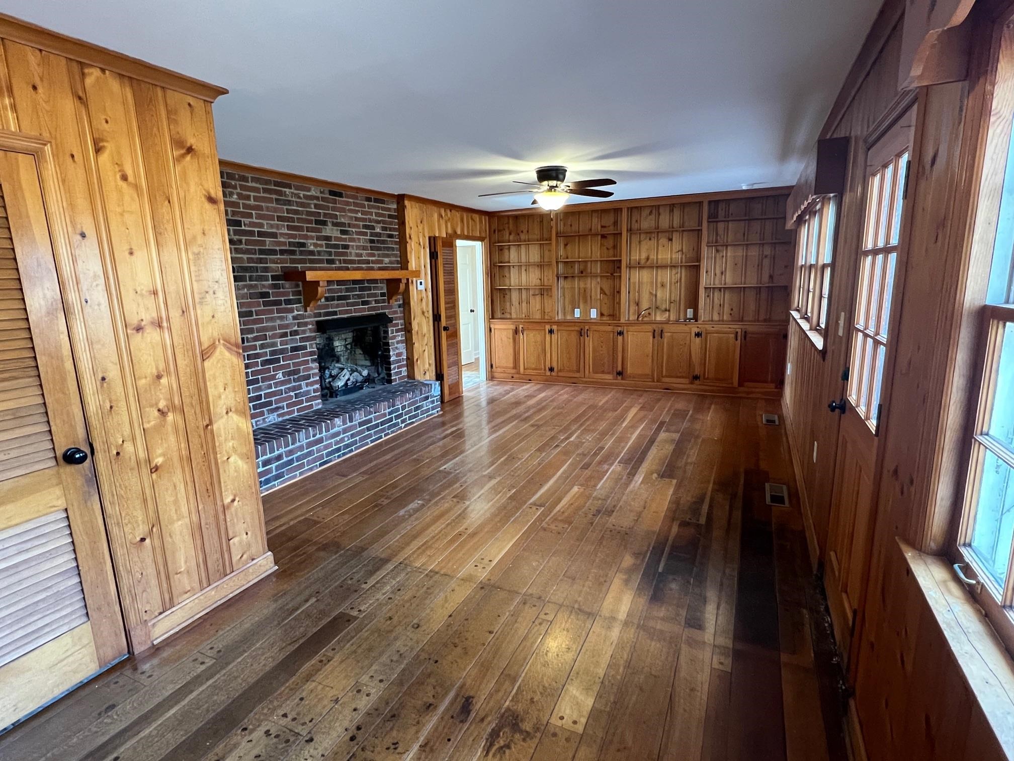 262 East Poplar Avenue Collierville, TN 38017 - Photo 6 of 19 a empty room with wooden floor and fireplace