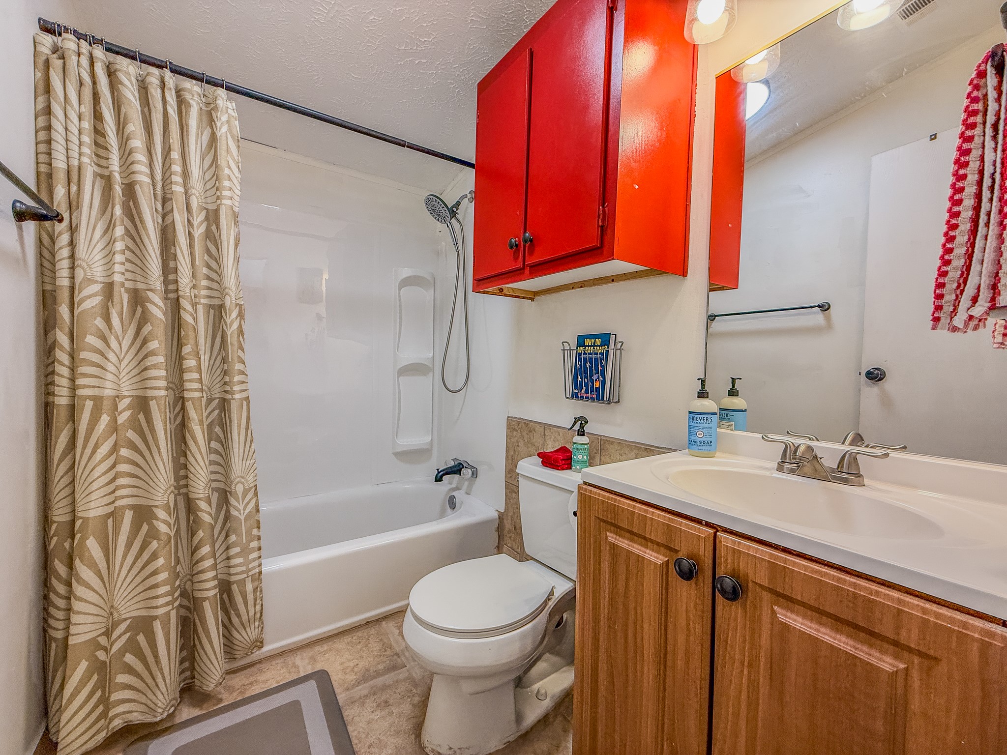 2015 Holly Street Austin, TX 78702 - Photo 20 of 24 Functional full bathroom featuring a tub and shower combination with practical vanity storage.