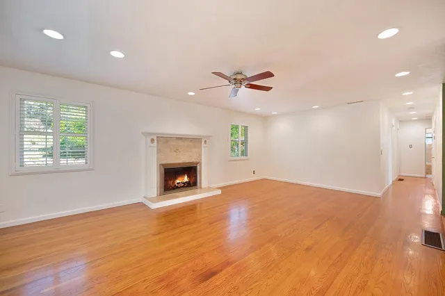 a view of an empty room with a fireplace and a window