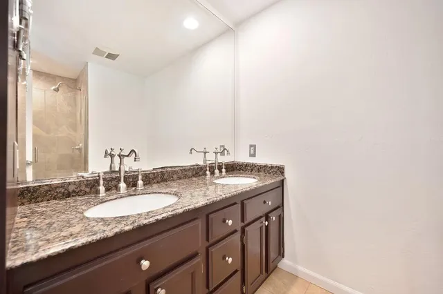a bathroom with a granite countertop sink and a mirror