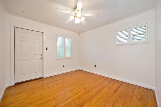 an empty room with windows and fan