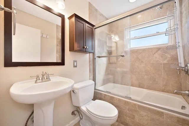 a bathroom with a sink a toilet and shower