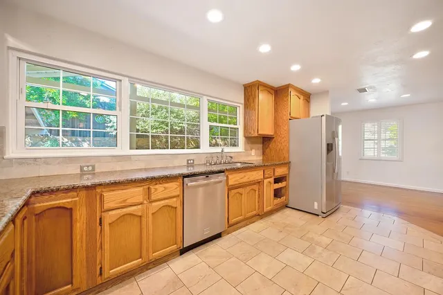 a kitchen with stainless steel appliances granite countertop a refrigerator and a sink